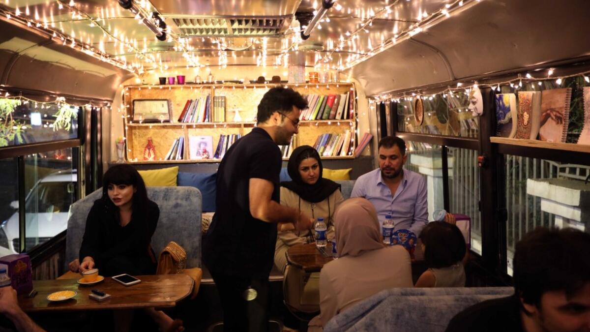 People have a drink at "The Bus Cafe Erbil" in Arbil, the capital of Iraq's Kurdish autonomous region, on June 7, 2019, on the long weekend of the Eid al-Fitr holiday which marks the end of the Muslim holy month of Ramadan.  SAFIN HAMED / AFP