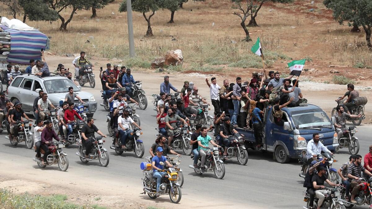 A convoy of Syrians follow the truck carrying the coffin of late rebel fighter Abdel-Basset al-Sarout on June 9, 2019, near the Bab al-Hawa crossing point, northwestern Syria, on the way to his funeral after crossing the border from Turkey where he was receiving treatment following his injury earlier this week. OMAR HAJ KADOUR / AFP