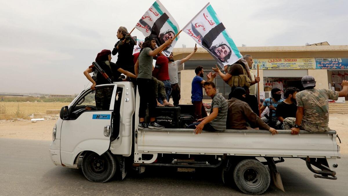 A convoy of Syrians follow the truck carrying the coffin of late rebel fighter Abdel-Basset al-Sarout on June 9, 2019, near the Bab al-Hawa crossing point, northwestern Syria, on the way to his funeral after crossing the border from Turkey where he was receiving treatment following his injury earlier this week. OMAR HAJ KADOUR / AFP