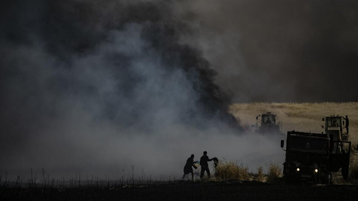People battle a blaze next to an oil well in an agricultural field in the town of al-Qahtaniyah, in the Hasakeh province near the Syrian-Turkish border on June 10, 2019. Fires have erupted in various parts of Syria in recent weeks, with all sides blaming each other for starting them. Delil souleiman / AFP