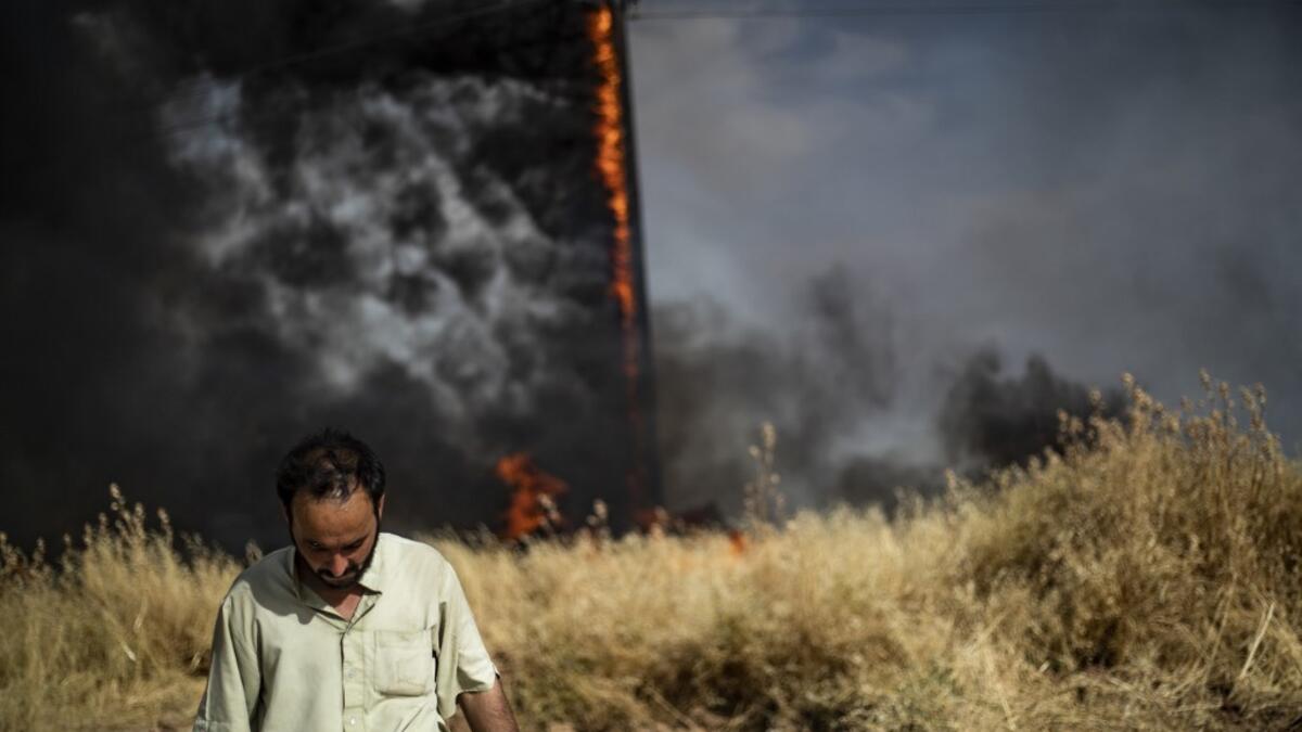 People battle a blaze next to an oil well in an agricultural field in the town of al-Qahtaniyah, in the Hasakeh province near the Syrian-Turkish border on June 10, 2019. Fires have erupted in various parts of Syria in recent weeks, with all sides blaming each other for starting them. Delil souleiman / AFP