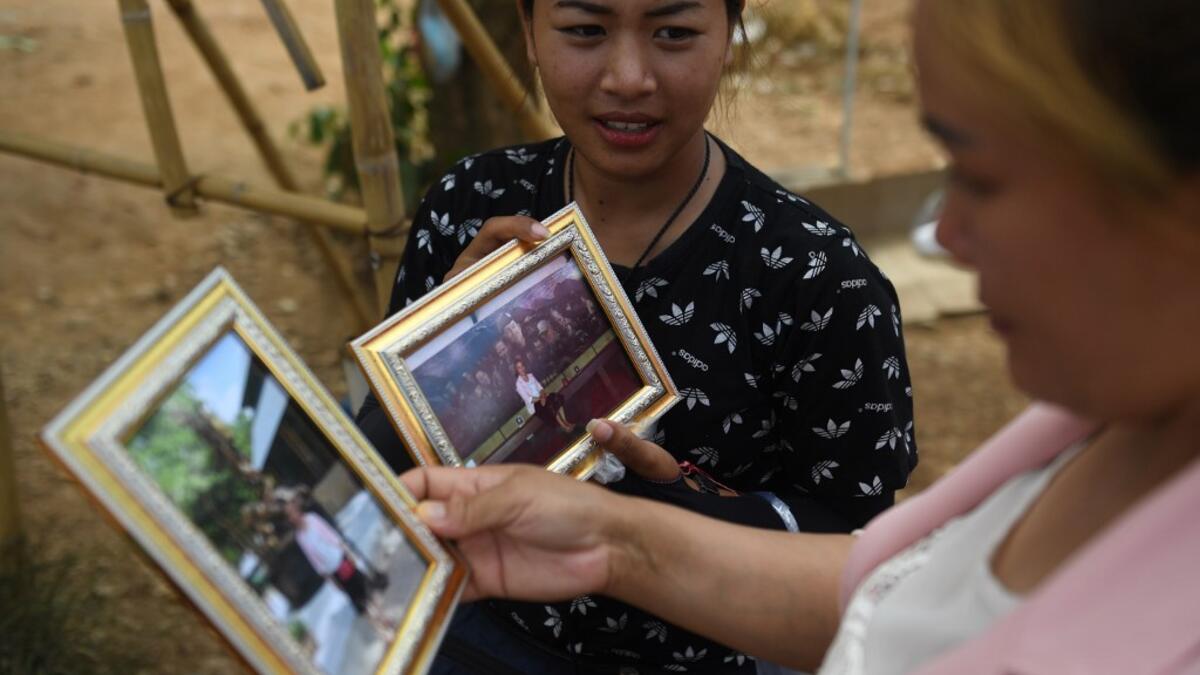 This picture taken on June 13, 2019 shows vendors selling souvenir photos near the entrance of the Tham Luang cave, in which 12 boys from the "Wild Boars" football team and their coach were trapped last year, in the Mae Sai district of Chiang Rai province. Lillian SUWANRUMPHA / AFP