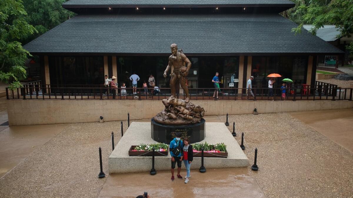 This aerial picture taken on June 15, 2019 shows visitors having their photo taken at the visitor centre for the Tham Luang cave, where 12 boys from the "Wild Boars" football team and their coach were trapped last year, in the Mae Sai district of Chiang Rai province. Lillian SUWANRUMPHA / AFP