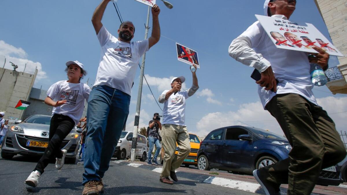 Palestinians hold protest signs showing the crossed-out faces of (L to R) Israeli Prime Minister Benjamin Netanyahu, US President Donald Trump, King Hamad al-Khalifa of Bahrain, and Saudi Crown Prince Mohammed bin Salman. Musa Al SHAER / AFP
