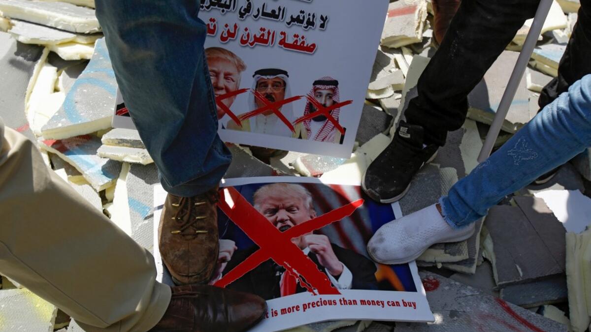 Palestinians stamp on protest signs showing the crossed-out faces of (L to R)  Israeli Prime Minister Benjamin Netanyahu, US President Donald Trump,  King Hamad al-Khalifa of Bahrain, and Saudi Crown Prince Mohammed bin  Salman, with a caption above in Arabic reading "Palestine is not for sale,  no to the conference of shame in Bahrain, the deal of the century will not pass". Musa Al SHAER / AFP