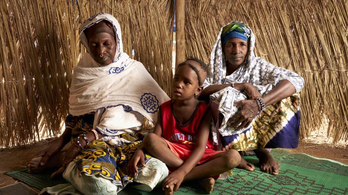 Dicko Sidibe (R) poses with her daughter and her sister Soutra (L) in a refugee camp on May, 13, 3019 in Bamako. After receiving several threats and attacks against their village in the province of Bankass, they fled central Mali to find a safe place in Bamako. (MICHELE CATTANI / AFP)