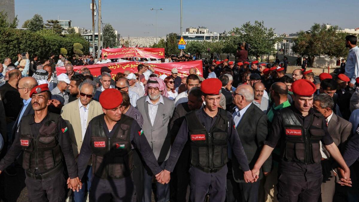 Jordanian security forces create a security perimeter around protesters  participating in the "March of Anger" demonstration leading to the US Embassy  in the Jordanian capital Amman on June 21, 2019, against the US President Donald Trump's "Deal of the Century" and the US-led Middle East economic conference in Bahrain.  Khalil MAZRAAWI / AFP