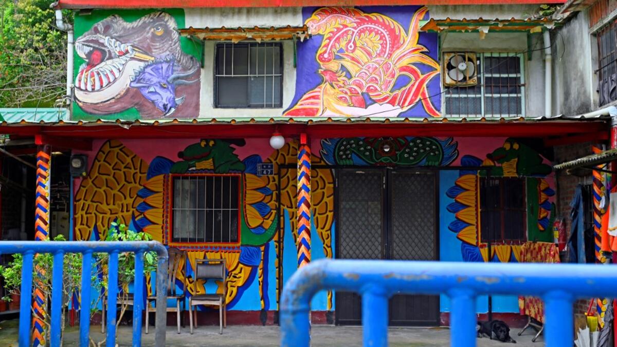 This picture taken on March 30, 2019 shows a dog sleeping in the courtyard of a house painted by Hakka graffiti artist Wu Tsun-hsien in the Taiwanese village of Ruan Chiao. Nestled in the mist-covered foothills of Taiwan's central mountain range, Ruan Chiao village is virtually devoid of young people, but artist Wu Tsun-hsien is coaxing the Instagram generation back by transforming local homes into a canvas of colour. Sam YEH / AFP