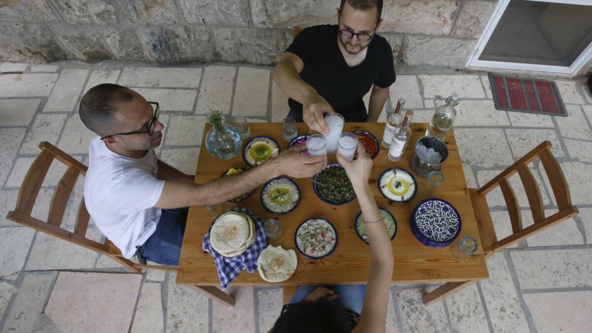 Palestinian distiller Nader Muaddi drinks his handcrafted Arak in the occupied West Bank city of Beit Jala, near Bethlehem, on June 16, 2019. In his basement, distiller Muaddi made fewer than 500 bottles of liquor last year, but it is earning global acclaim and reviving interest in the Palestinian alcohol sector. On the outskirts of the city famed for Jesus's birth, the 35-year-old illustrates the handcrafted way he makes Arak, an anise-flavoured drink popular in the Middle East and similar to Greek Ouzo, F