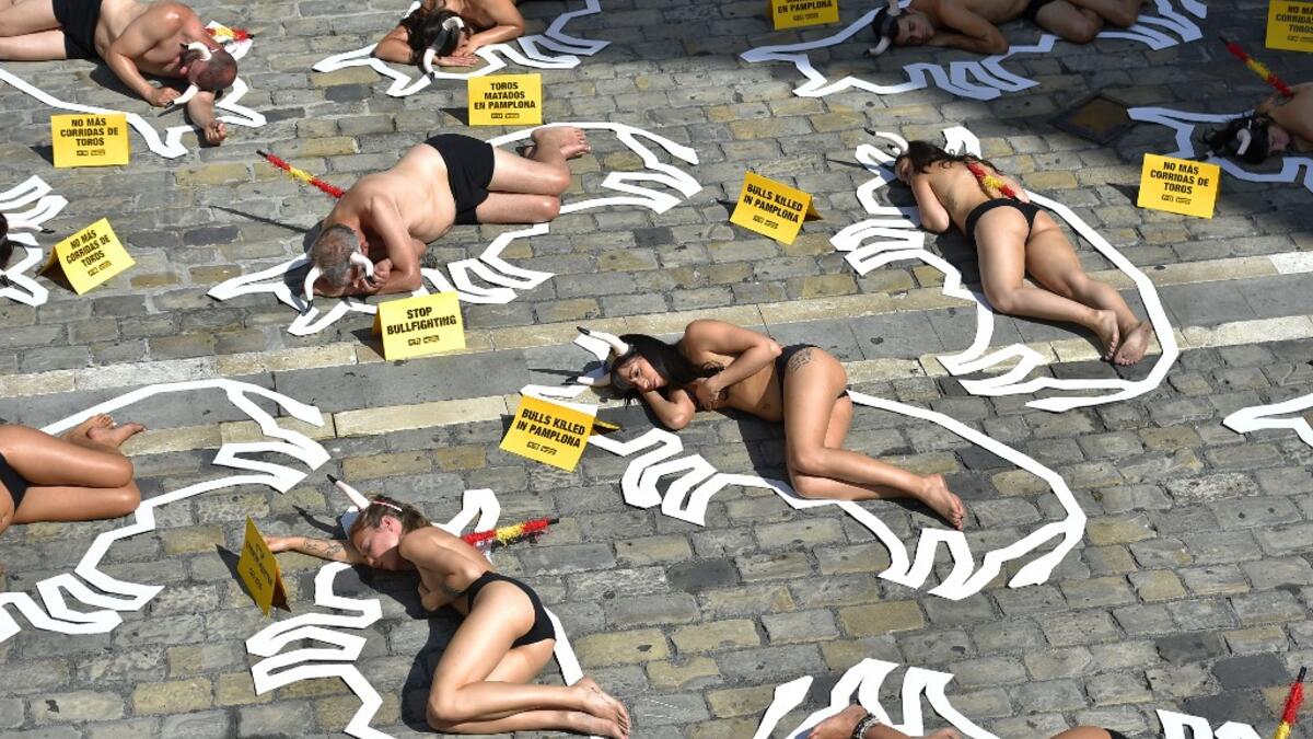 Pro-animal rights activists lie on the ground during a protest against bullfighting and bull-running called by the People for the Ethical Treatment of Animals (PETA) pro-animal group on the eve of the San Fermin festivities in the Northern Spanish city of Pamplona on July 5, 2019.  ANDER GILLENEA / AFP