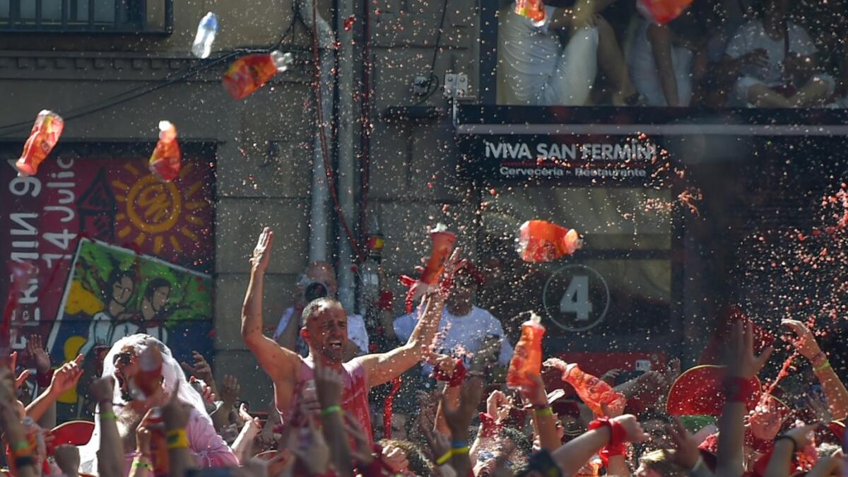 Revellers celebrate during the 'Chupinazo' (start rocket) to mark the kickoff at noon sharp of the San Fermin Festival, in front of the Town Hall of Pamplona, northern Spain, on July 6, 2019.  ANDER GILLENEA / AFP