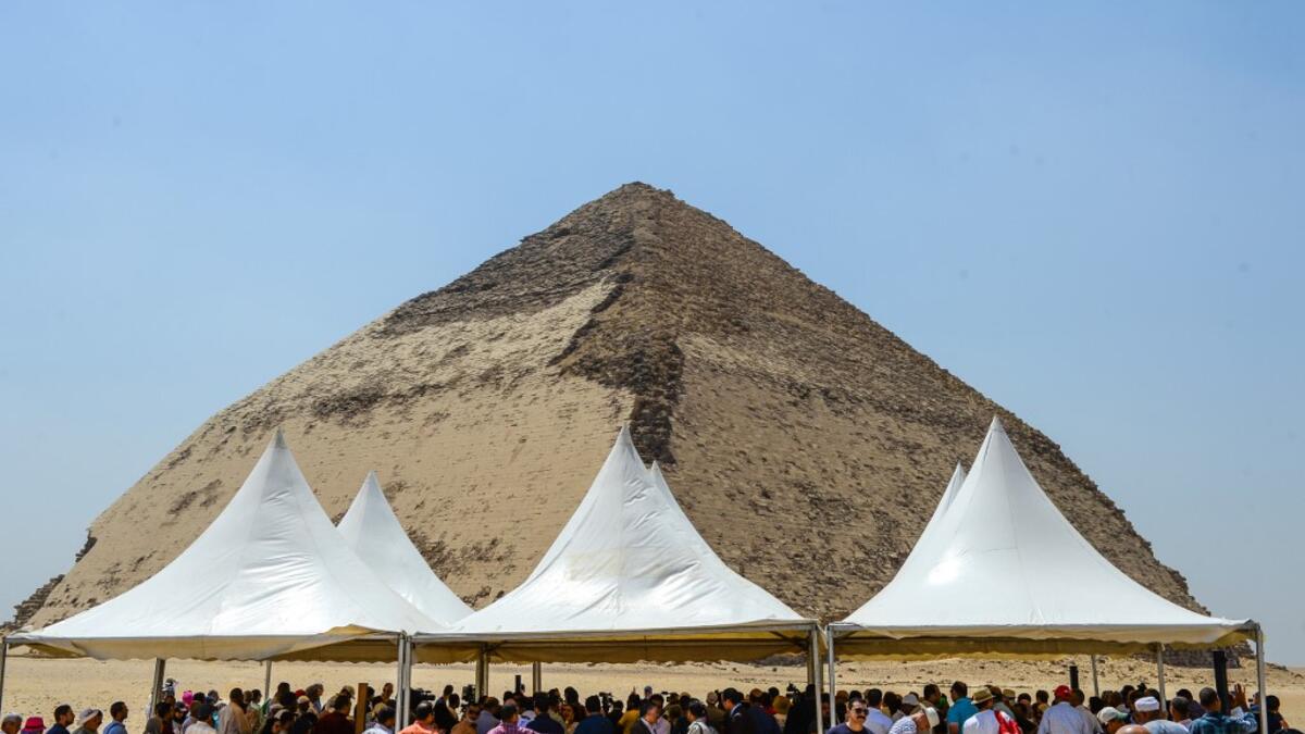 People gather during an inaugural ceremony in front of the Bent pyramid of King Sneferu, the first pharaoh of Egypt's 4th dynasty, in the ancient royal necropolis of Dahshur on the west bank of the Nile River, south of the capital Cairo on July 13, 2019. Mohamed el-Shahed / AFP