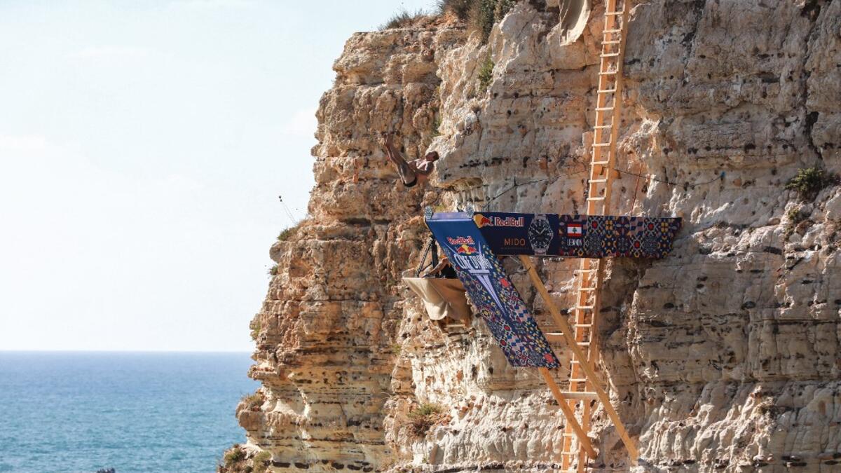 A cliff diver jumps from a platform on the landmark Raouche sea rock off the coast of the Lebanese capital Beirut on July 14, 2019, during the men's 2019 Red Bull Cliff Diving World Series.  ANWAR AMRO / AA / AFP