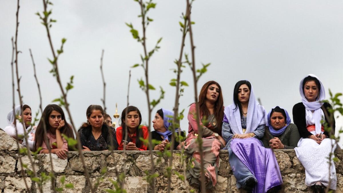 Iraqi Yazidi women sit outside the Temple of Lalish, in a valley near the Kurdish city of Dohuk about 430 kilometres northwest of the capital Baghdad, on April 16, 2019, during a ceremony marking the Yazidi New Year. SAFIN HAMED /
