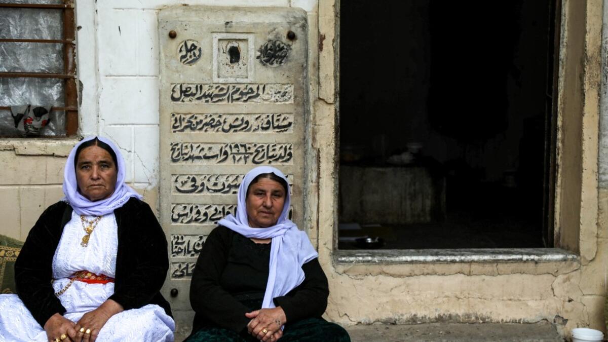 Iraqi Yazidi women sit outside the Temple of Lalish, in a valley near the Kurdish city of Dohuk about 430 kilometres northwest of the capital Baghdad, on April 16, 2019, during a ceremony marking the Yazidi New Year. Roughly 3,300 Yazidis have returned from IS captivity in the last five years, only 10 percent of them men. SAFIN HAMED /
