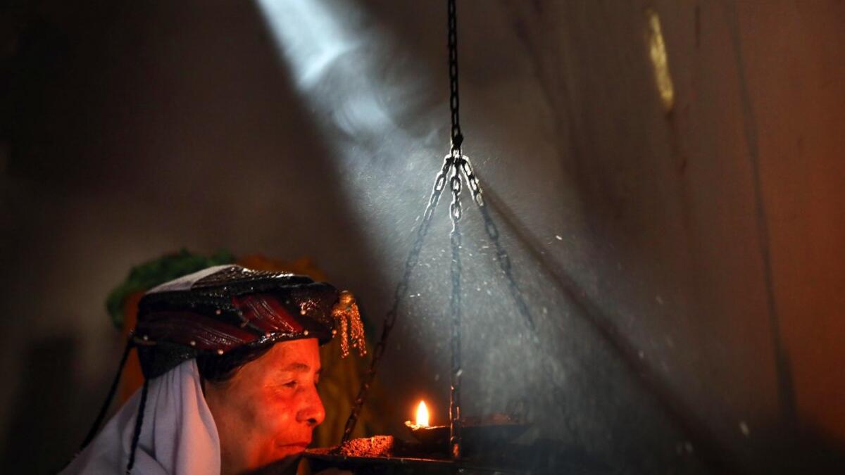 An Iraqi Yazidi woman prays at the Temple of Lalish, in a valley near the Kurdish city of Dohuk about 430km northwest of the capital Baghdad, on July 16, 2019. SAFIN HAMED / AFP