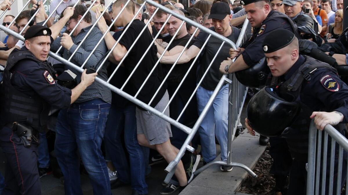 Protesters attempt to break through a police cordon during an unauthorised rally demanding independent and opposition candidates be allowed to run for office in local election in September, in downtown Moscow on July 27, 2019.  Maxim ZMEYEV / AFP