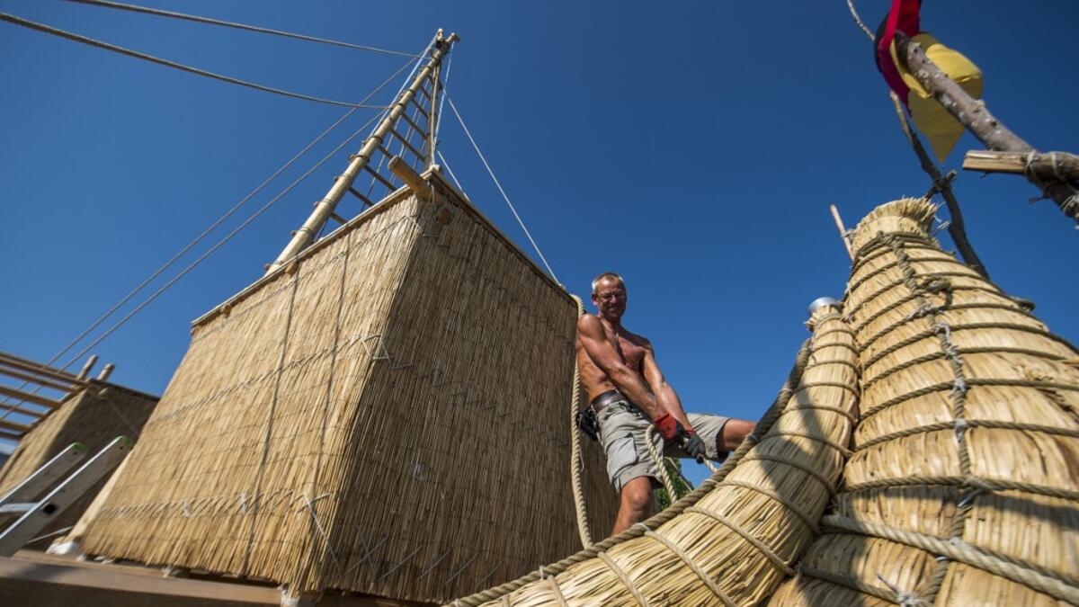 A member of the crew assembles the 14-meter long sailing reed boat Abora IV in the town of Beloslav, Bulgaria, on July 25, 2019. NIKOLAY DOYCHINOV / AFP