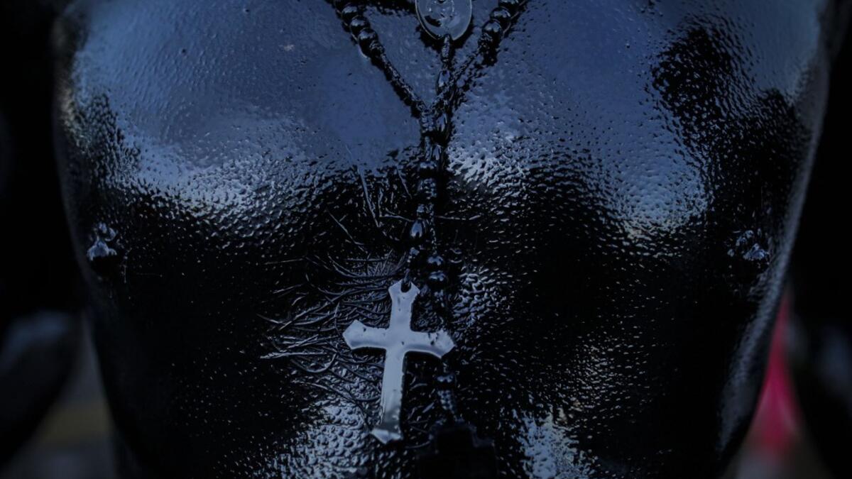 A catholic faithful smeared in burnt oil, takes part in the opening of the ten-day celebration of the Santo Domingo de Guzman festival in Managua, on August 1, 2019.  INTI OCON / AFP