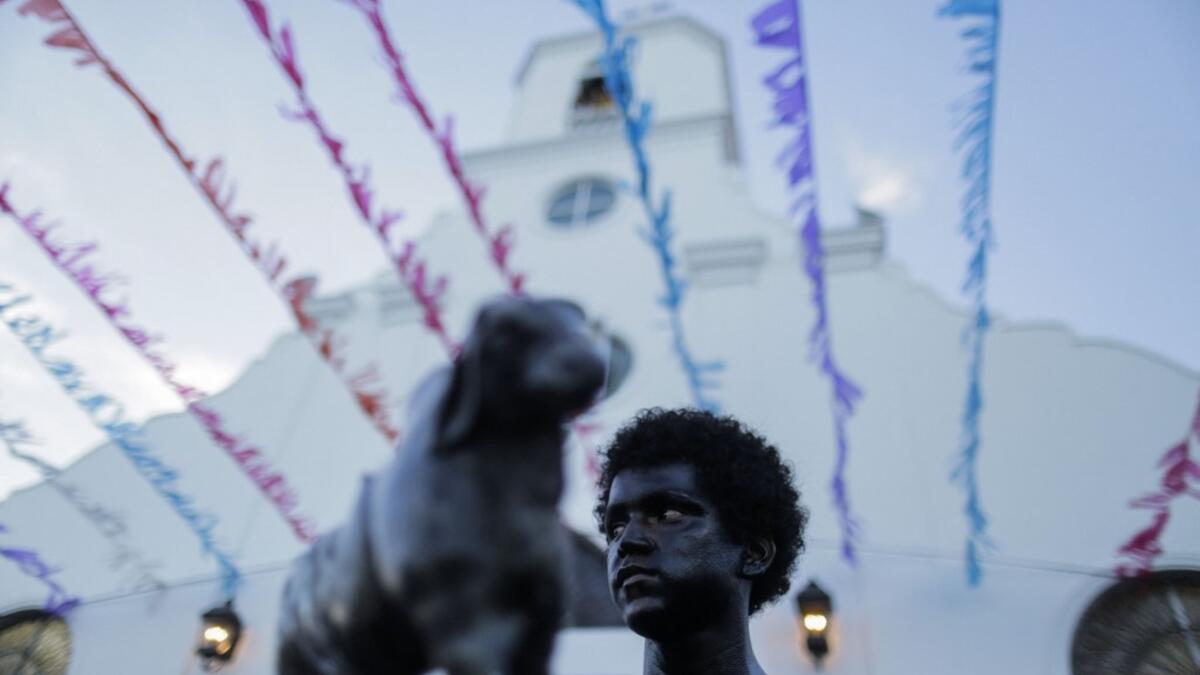 A catholic faithful smeared in burnt oil, takes part in the opening of the ten-day celebration of the Santo Domingo de Guzman festival in Managua, on August 1, 2019.  INTI OCON / AFP