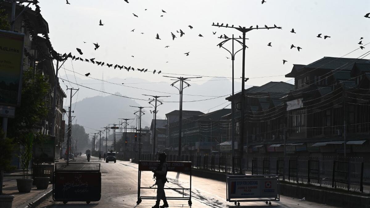 A security personnel stands guard at a roadblock during a curfew in Srinagar on August 6, 2019. India's home affairs minister on August 6 hailed "historic" legislation to bring Kashmir under its direct control, as New Delhi stepped up its clampdown on dissent in the restive Muslim-majority region. Tauseef MUSTAFA / AFP
