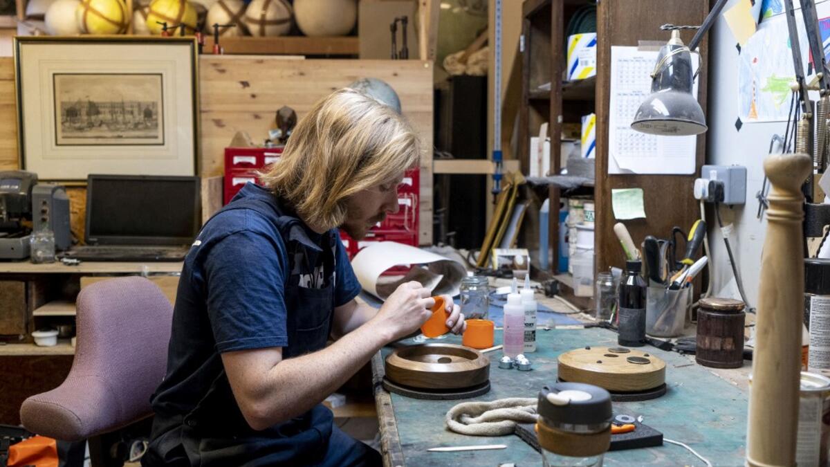 A woodworker prepares a base for a globe at the Bellerby and Co Globemakers' workshop and headquarters in Stoke Newington in north London, on July 19, 2019. Niklas HALLE'N / AFP