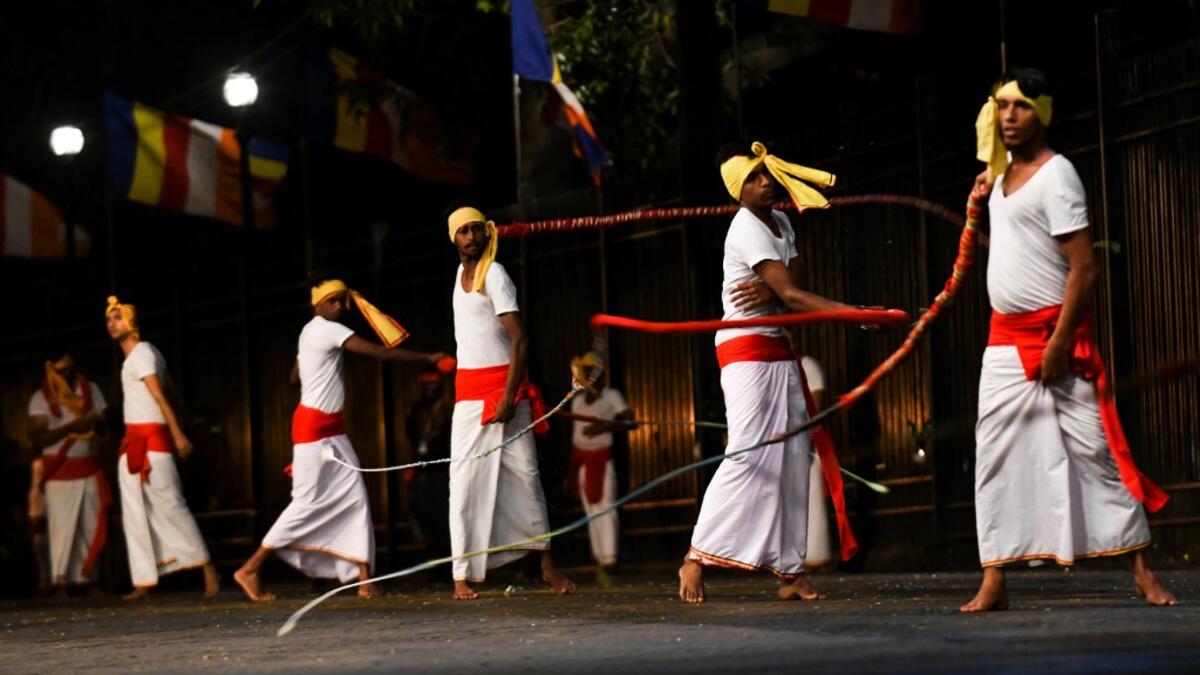 In this photograph taken on August 14, 2019 dancers perform during the "Esala Perahera" festival near the Buddhist temple of the Tooth in the ancient hill capital of Kandy, some 116 kilometres from Colombo. LAKRUWAN WANNIARACHCHI / AFP