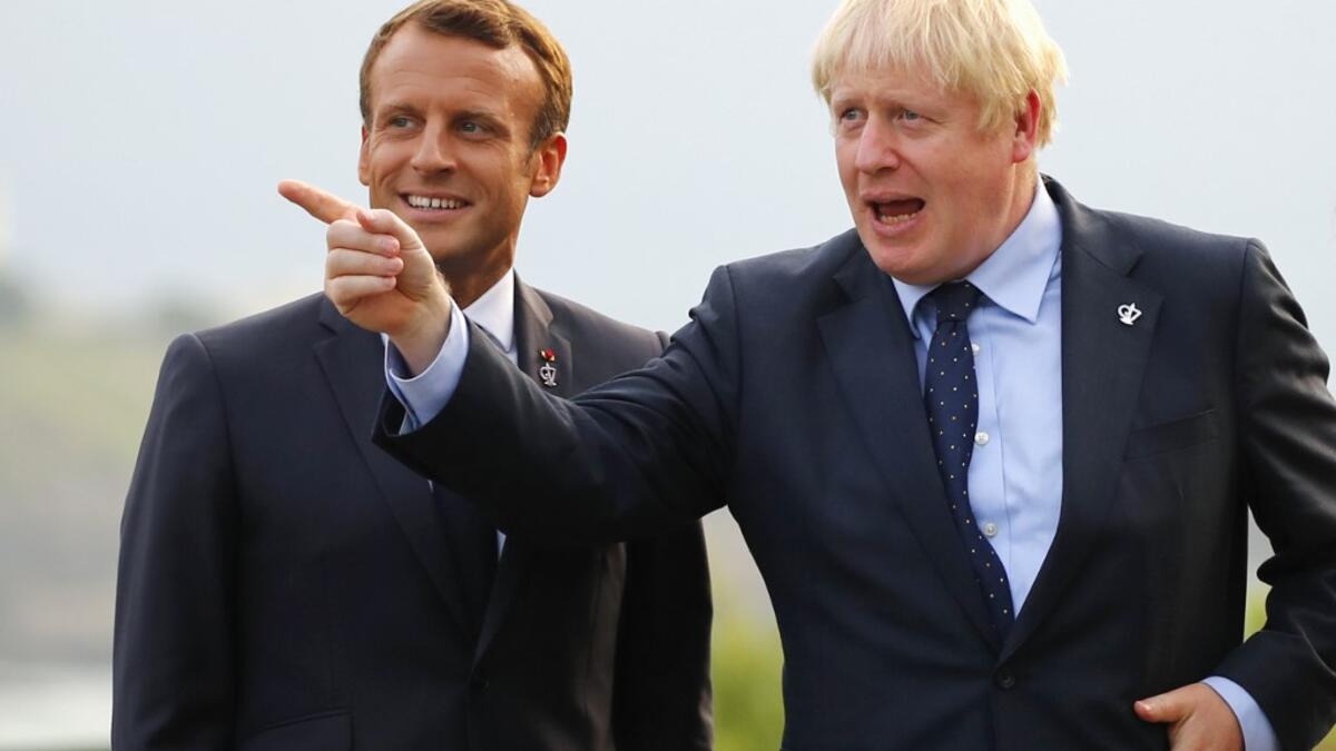 British Prime Minister Boris Johnson (R) gestures past French President Emmanuel Macron at the Biarritz lighthouse, southwestern France, ahead of a working dinner on August 24, 2019. Francois Mori / POOL / AFP