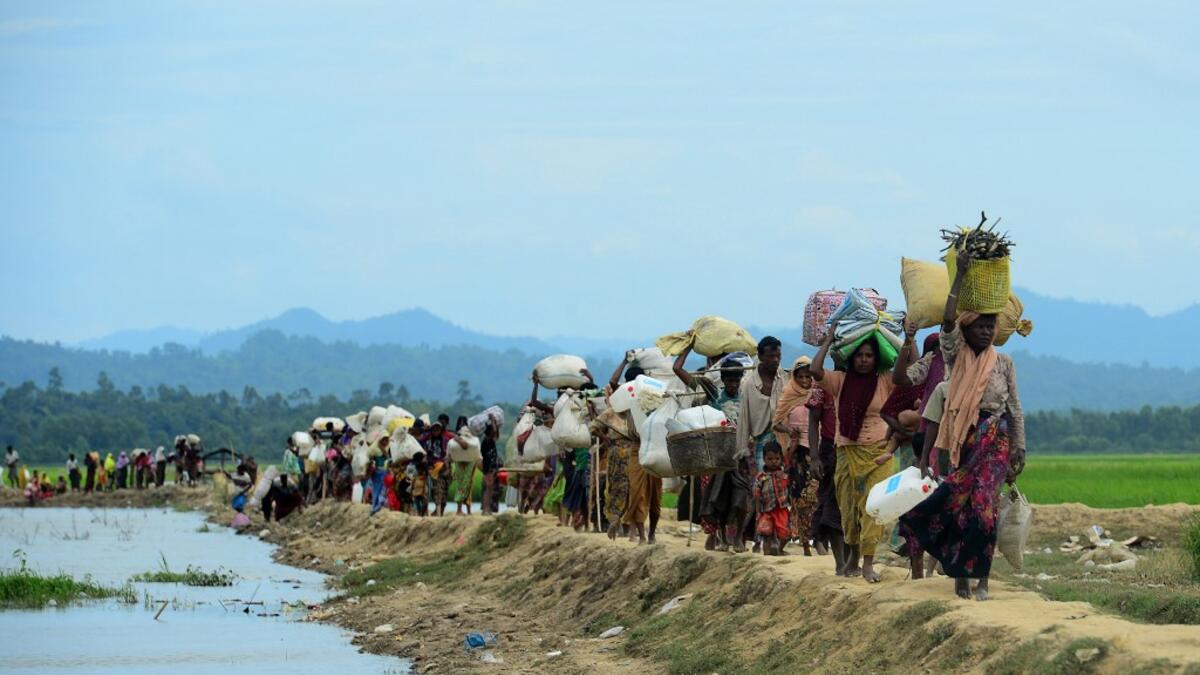 October 19, 2017 Rohingya refugees who were stranded walk near the no man's land area between Bangladesh and Myanmar in the Palongkhali area next to Ukhia. Munir UZ ZAMAN / AFP