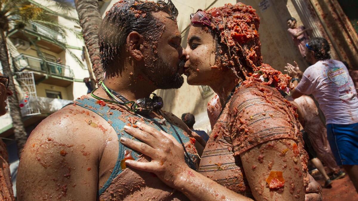 Revellers covered in tomato pulpkiss during the annual "Tomatina" festival in the eastern town of Bunol, on August 28, 2019. JAIME REINA / AFP