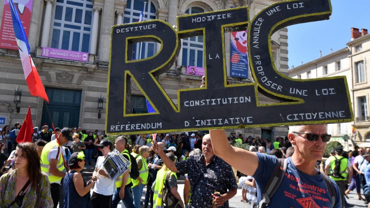 A protester holds a sign reading "RIC" (for "Citizen's Initiated Referendum") during an anti-government demonstration called by the "Yellow Vests" (Gilets Jaunes) movement on September 7, 2019 in Montpellier, southern France. Pascal GUYOT / AFP