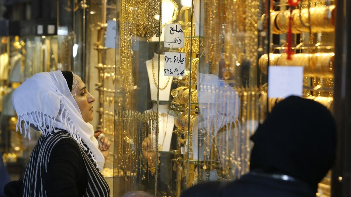 Women gaze at the window of a jewelry shop at the Bzourieh market in the centre of the Syrian.  LOUAI BESHARA / AFP
