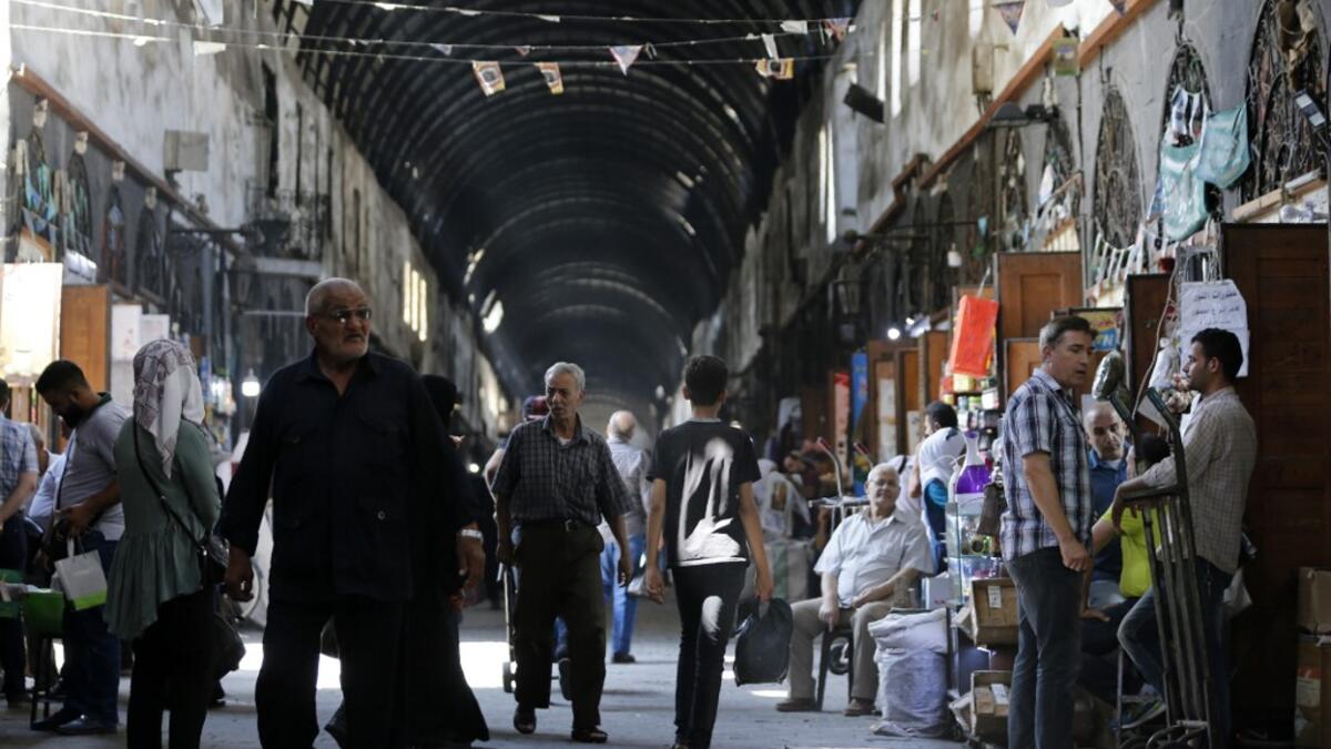 Shoppers walk through the Bzourieh market in the centre of the Syrian capital Damascus. LOUAI BESHARA / AFP