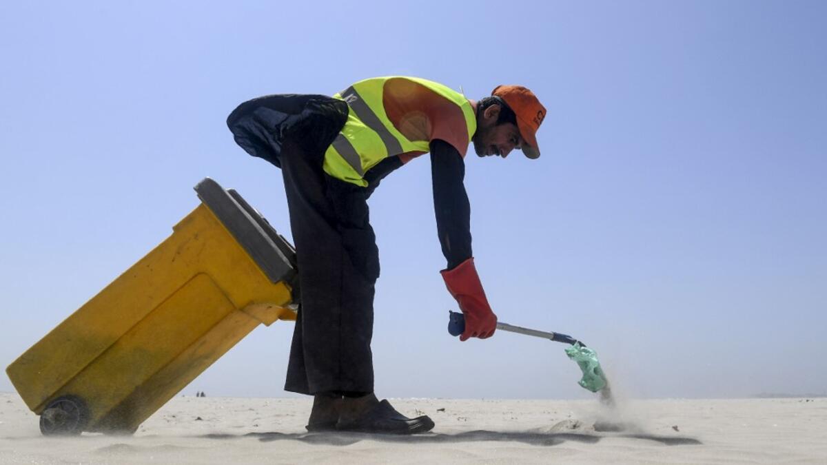 A worker of Cantonment Board Clifton (CBC) collects plastic and other waste from the Clifton beach in Karachi on September 19, 2019. ASIF HASSAN / AFP