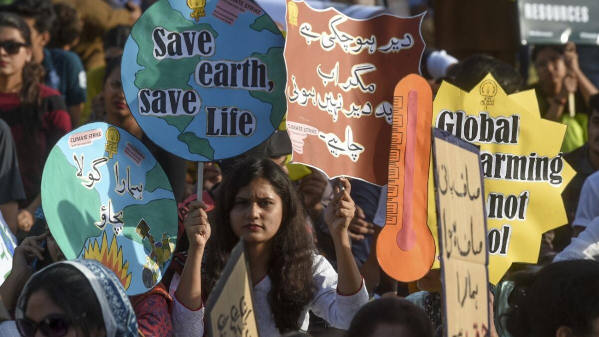 Youths hold placards as they march for a climate strike to protest against governmental inaction towards climate breakdown and environmental pollution, part of demonstrations being held worldwide in a movement dubbed "Fridays for Future", in Karachi on September 20, 2019. ASIF HASSAN / AFP