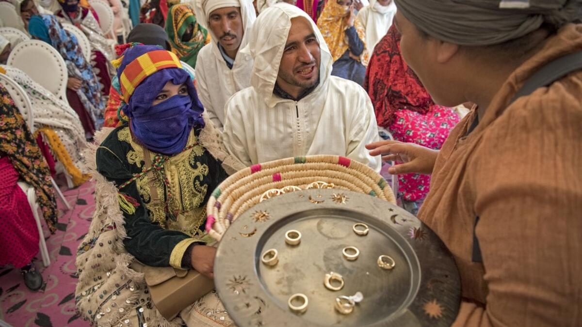 Young Amazigh (Berber) men and women wait for their wedding ceremony during the annual "Engagement Moussem" festival near the village of Imilchil in central Morocco's high Atlas Mountains on September 21, 2019. Each year in the High Atlas Mountains hamlet of Ait Amer, tribes celebrate with dances and music, the collective wedding of young Amazigh couples during the traditional festival of "Engagement Moussem". FADEL SENNA / AFP