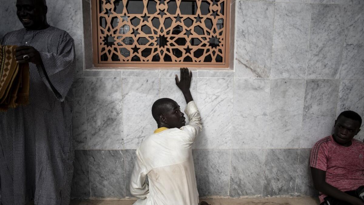 Worshippers are seen waiting outside the Great Mosque of the Mourides on September 27, 2019 in Dakar, ahead of its inauguration. Senegal's influential Mouride Brotherhood will inaugurate a 30,000-capacity mosque in the capital Dakar, said to be the largest in West Africa. JOHN WESSELS / AFP