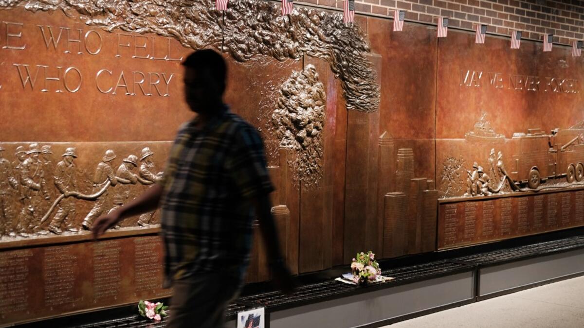 People walk by a memorial to fallen firefighters near the World Trade Center Memorial in lower Manhattan in New York City. New York City is preparing to commemorate the 18th anniversary of the attacks on the World Trade Center in which 2,996 people were killed and over 6000 were injured. Spencer Platt/Getty Images/AFP SPENCER PLATT / GETTY IMAGES NORTH AMERICA / AFP