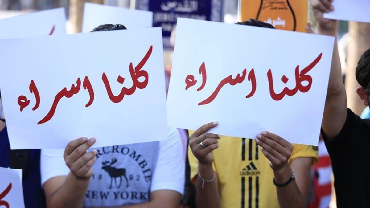 Arabic slogans on placards call for an end to violence against women and introducing a law for family protection against domestic violence."  (Twitter)