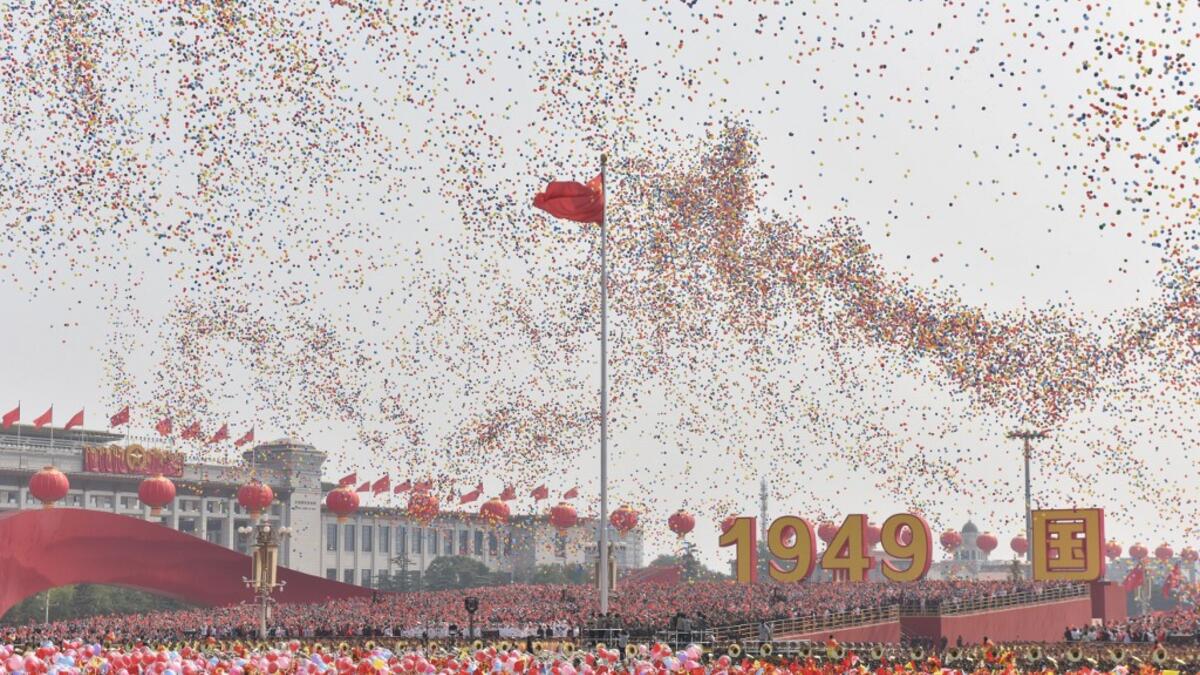 Balloons fly past the national flag at the end of a military parade at Tiananmen Square in Beijing on October 1, 2019, to mark the 70th anniversary of the founding of the People's Republic of China. GREG BAKER / AFP