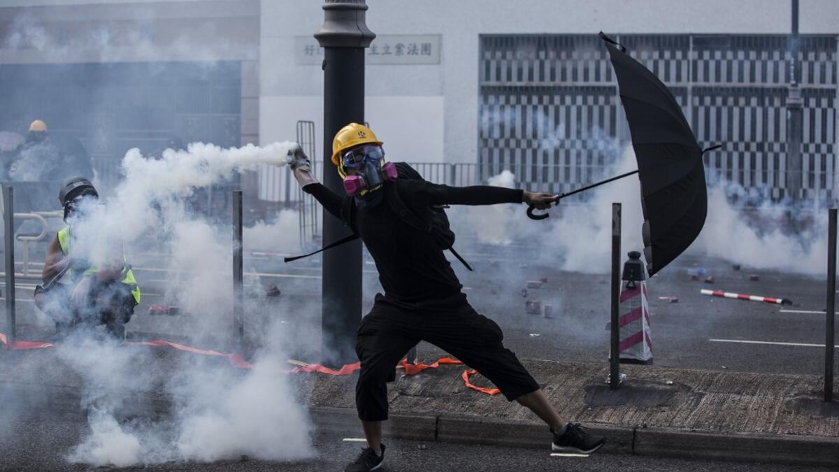 A protester throws a tear gas canister fired by police in the Sha Tin district of Hong Kong on October 1, 2019, as the city observes the National Day holiday to mark the 70th anniversary of communist China's founding. ISAAC LAWRENCE / AFP