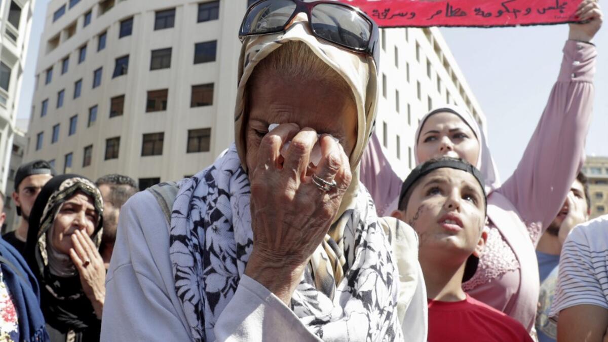 A Lebanese protester wipes her tears during a demonstration in central Beirut's Martyr Square on October 6, 2019. Lebanese protested in the capital over increasingly difficult living conditions, amid fears of a dollar shortage and possible price hikes. ANWAR AMRO / AFP