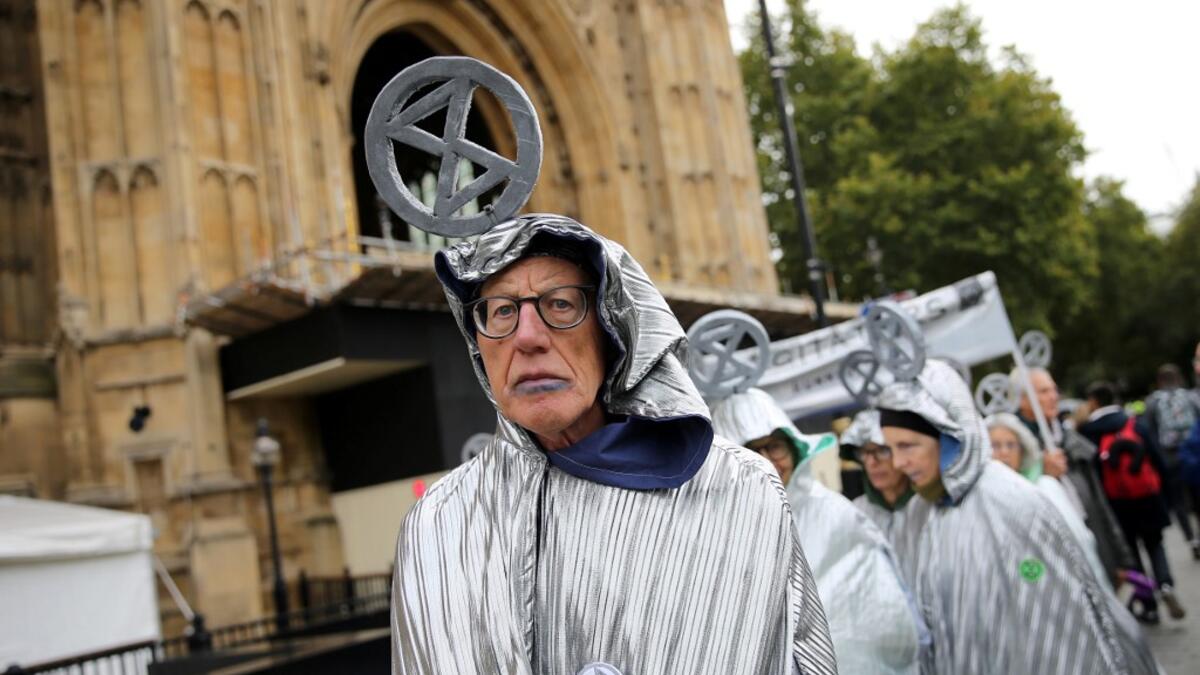 Demonstrators calling themselved 'Aged Agitators' wear the climate change activist group Extinction Rebellion's logo on their heads as they demonstrate outside the Houses of Parliament in central London, on October 7, 2019. Extinction Rebellion has scheduled non-violent protests chiefly in Europe, North America and Australia over the next fortnight. ISABEL INFANTES / AFP