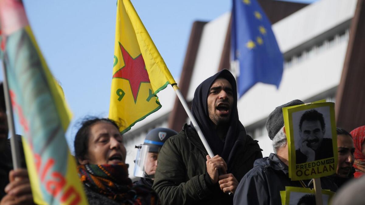 Kurdish demonstrators wave flags and hold portraits of Kurdish leader Abdullah Ocalan in front of the Council of Europe in Strasbourg, northeastern France, during a demonstration to protest against Turkey's military action in northern Syria on October 9, 2019. FREDERICK FLORIN / AFP
