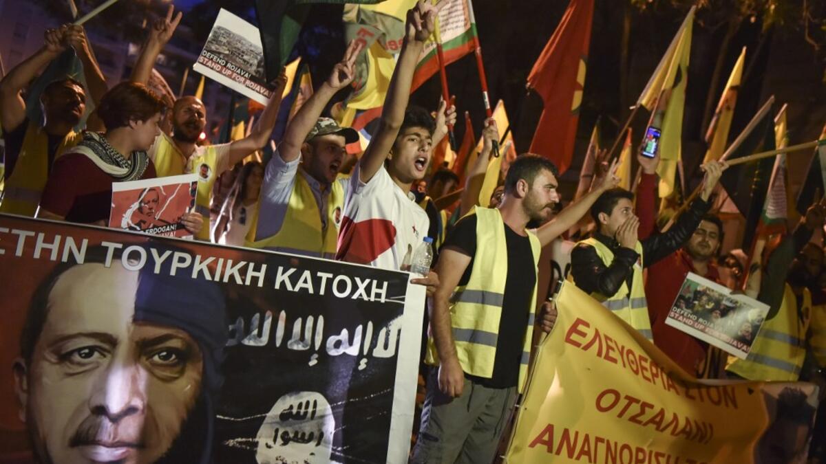 Kurds living in Athens hold flags and banners as they protest near the Turkish embassy in Athens, on October 9, 2019. Turkey launched an assault on Kurdish forces in northern Syria with air strikes and explosions reported along the border. President Recep Tayyip Erdogan announced the start of the attack on Twitter, labelling it "Operation Peace Spring". Louisa GOULIAMAKI / AFP