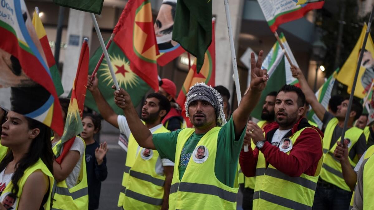 Kurds living in Athens hold flags during a protest near the Turkish embassy in Athens, on October 9, 2019. Louisa GOULIAMAKI / AFP