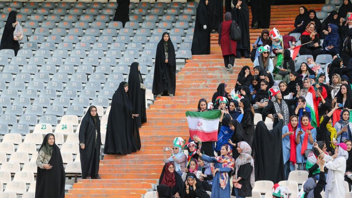 Iranian women cheer and wave their country's national flags as they attend the World Cup Qatar 2022 Group C qualification football match between Iran and Cambodia at the Azadi stadium in the capital Tehran on October 10, 2019. ATTA KENARE / AFP