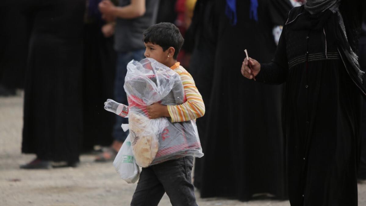 A Syrian girl carries a bag of aid distributed by the Turkish Red Crescent on October 19, 2019, in the Syrian border town of of Tal Abyad seized by Turkey-backed forces last week. Bakr ALKASEM / AFP