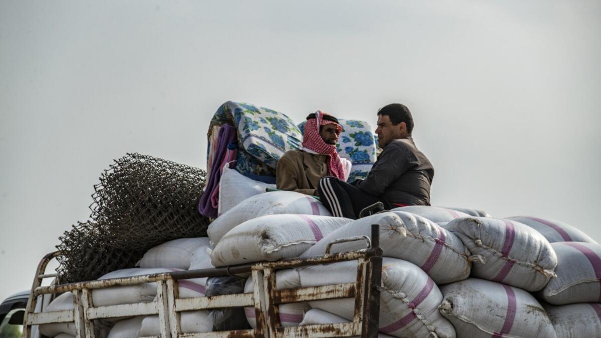 Syrian men flee with their belongings the countryside of the northeastern Syrian town of Ras al-Ain on the Turkish border, toward the west to the town of Tal Tamr on October 19, 2019. Turkey's President Recep Tayyip Erdogan fired off a fresh warning today to "crush" Kurdish forces as both sides traded accusations of violating a US-brokered truce deal in northeastern Syria. Delil SOULEIMAN / AFP