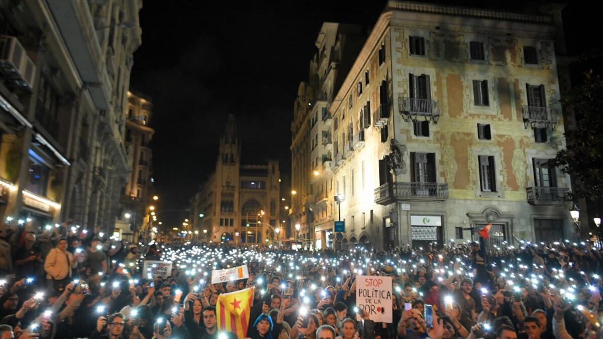 Protesters turn their smartphones' torches on during a protest in front of the Spanish national police headquarters in Barcelona on October 20, 2019. LLUIS GENE / AFP
